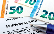 Symbolbild Betriebskosten: Geldscheine und Abrechnungsformular