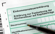 Symbolbild Steuerbonus: Ein Stift liegt auf einem noch nicht ausgefüllten Formular zur Abgabe der Einkommensteuererklärung