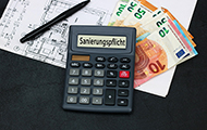 Symbolbild Sanierungspflicht: Taschenrechner, Gebäudeplan, Geldscheine